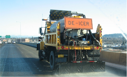 A de-icing truck spraying salt water on a highway.